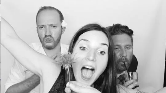 Schwarz‑weiß‑Schnappschuss von drei Personen, die Grimassen schneiden an der Snappix‑Fotobox
