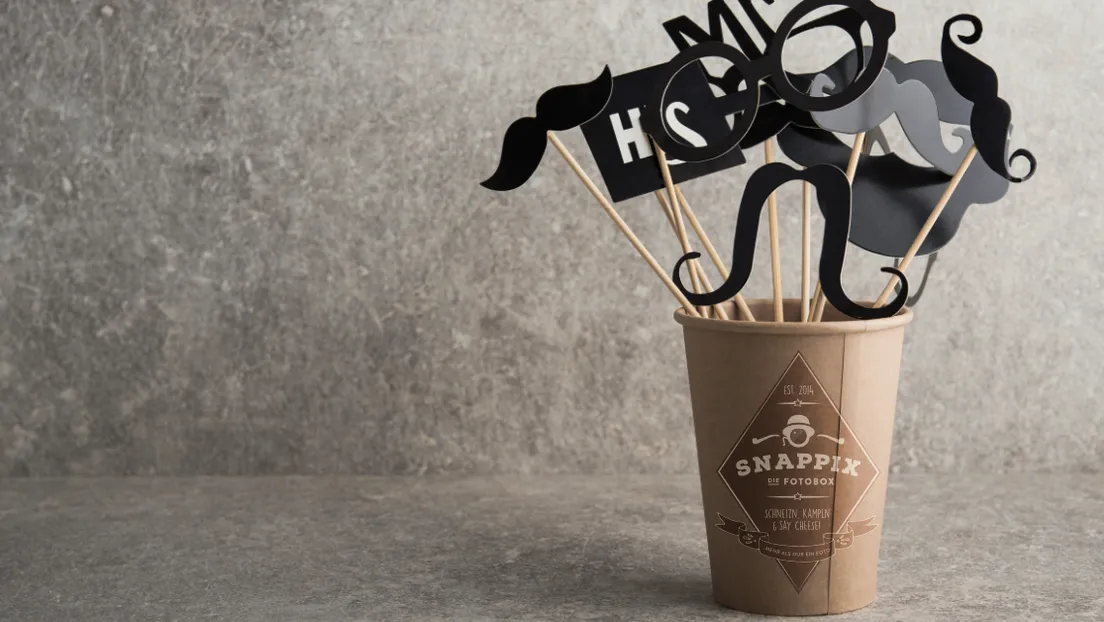 Scherz‑Requisiten wie Brillen und Schnurrbärte im Becher – Snappix‑Fotobox